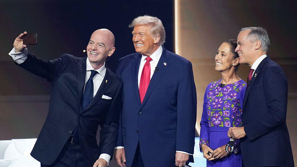 Gianni Infantino taking a selfie on stage with Donald Trump, Claudia Sheinbaum and Mark Carney.