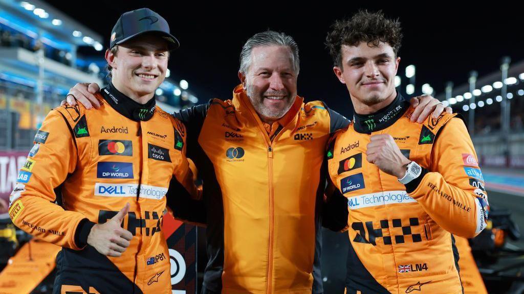 Oscar Piastri, Zak Brown and Lando Norris pose for photographs