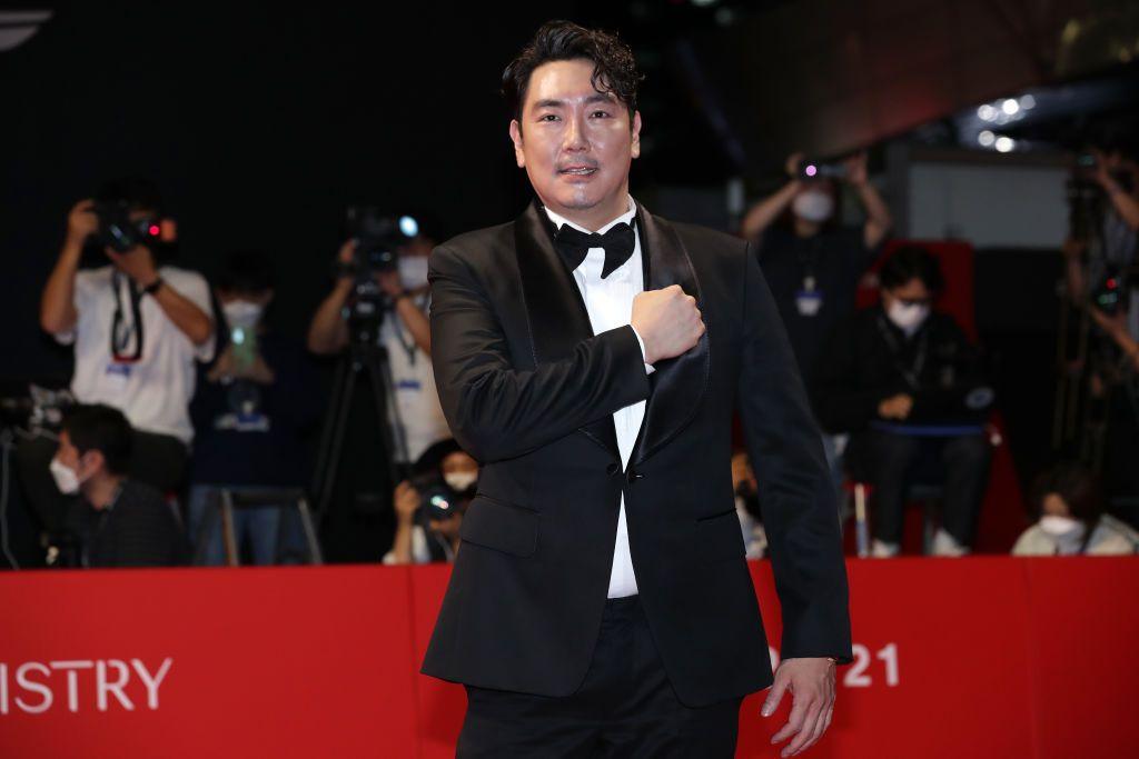 Cho Jin-woong in a black suit and bow tie poses on a red carpet