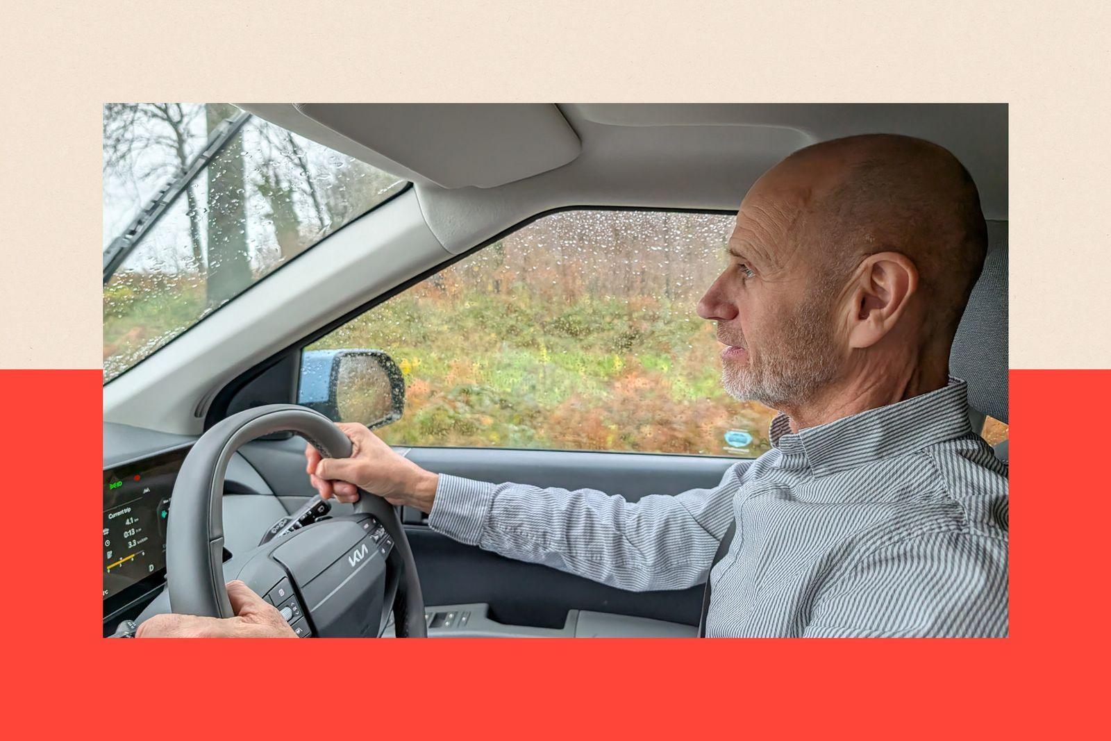 Evan Davis in a car, holding the driver's wheel