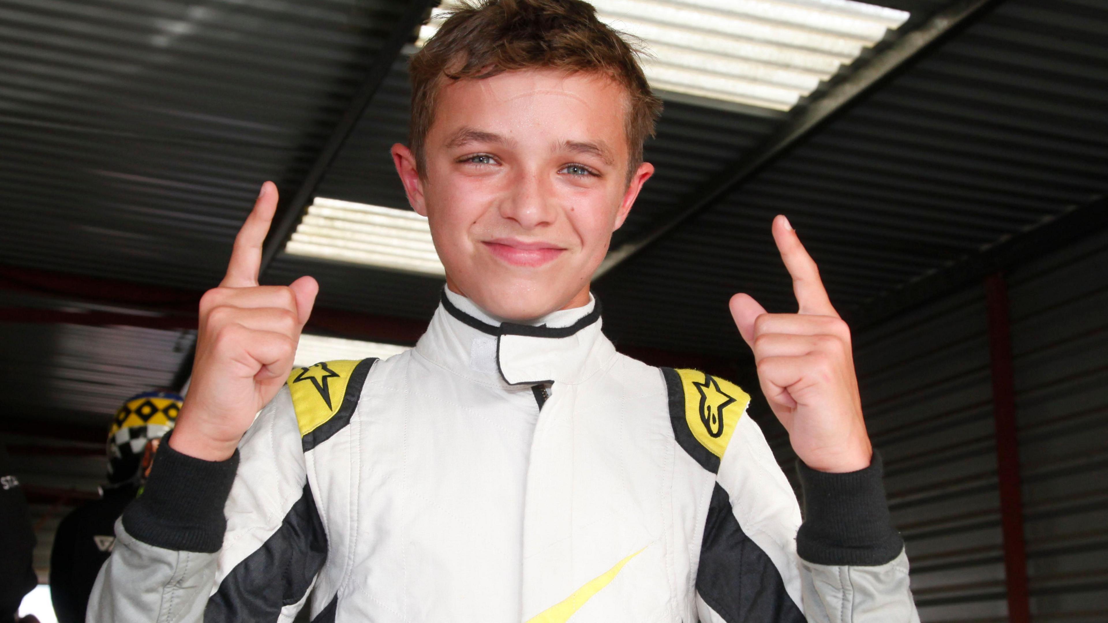 Norris celebrates by holding both index fingers in the air at Knockhill in 2014