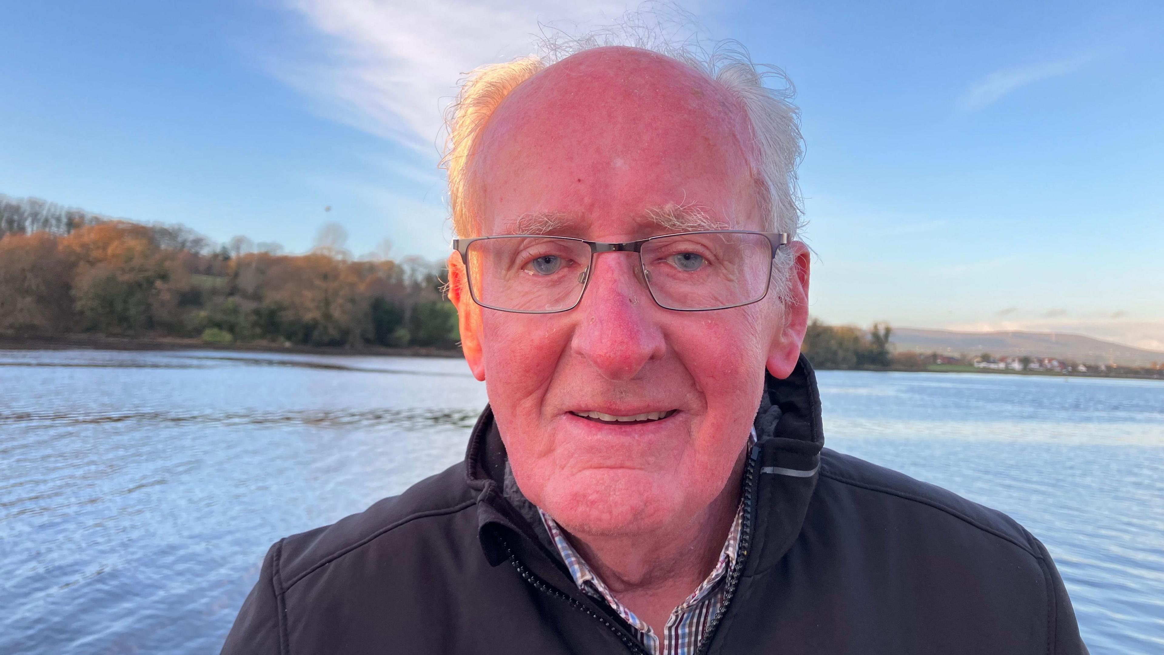Bert is ruddy faced and smiling gently, a beam of sun striking the side of his head. Behind him is the rippling water of Lough Foyle where many years ago he watched German U-boats emerge and the soldiers onboard disembark onto the quay.