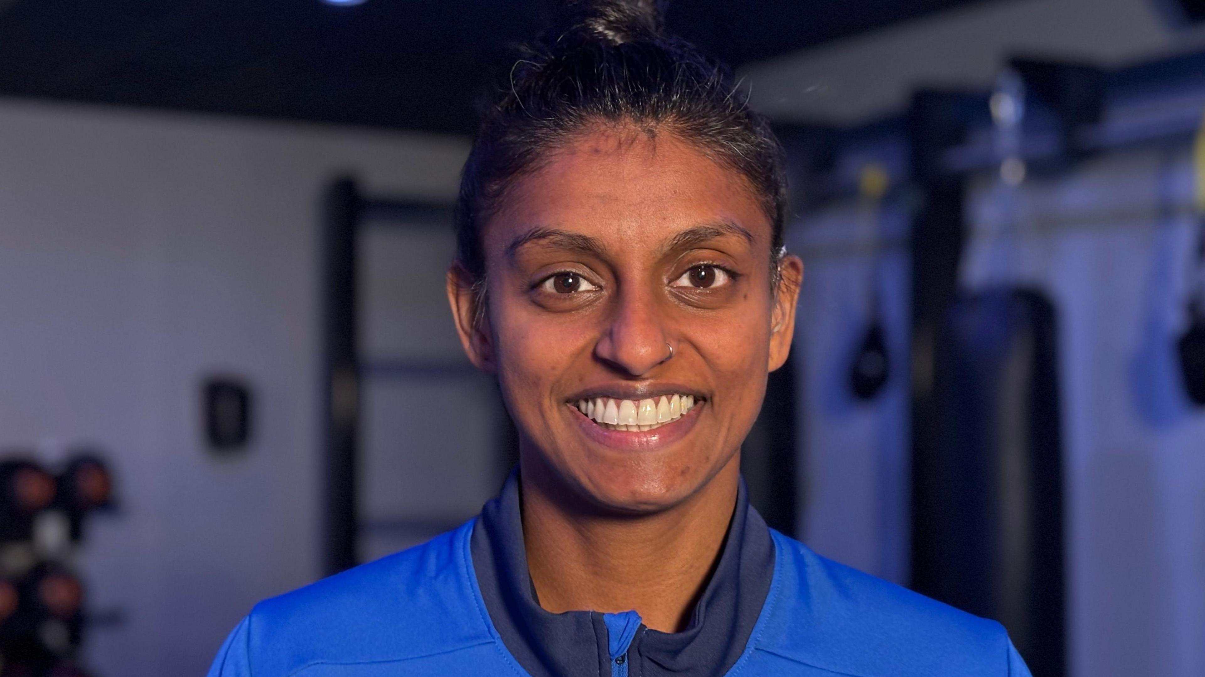 Lucindha Lawson wears a blue sport top and smiles, looking at the camera