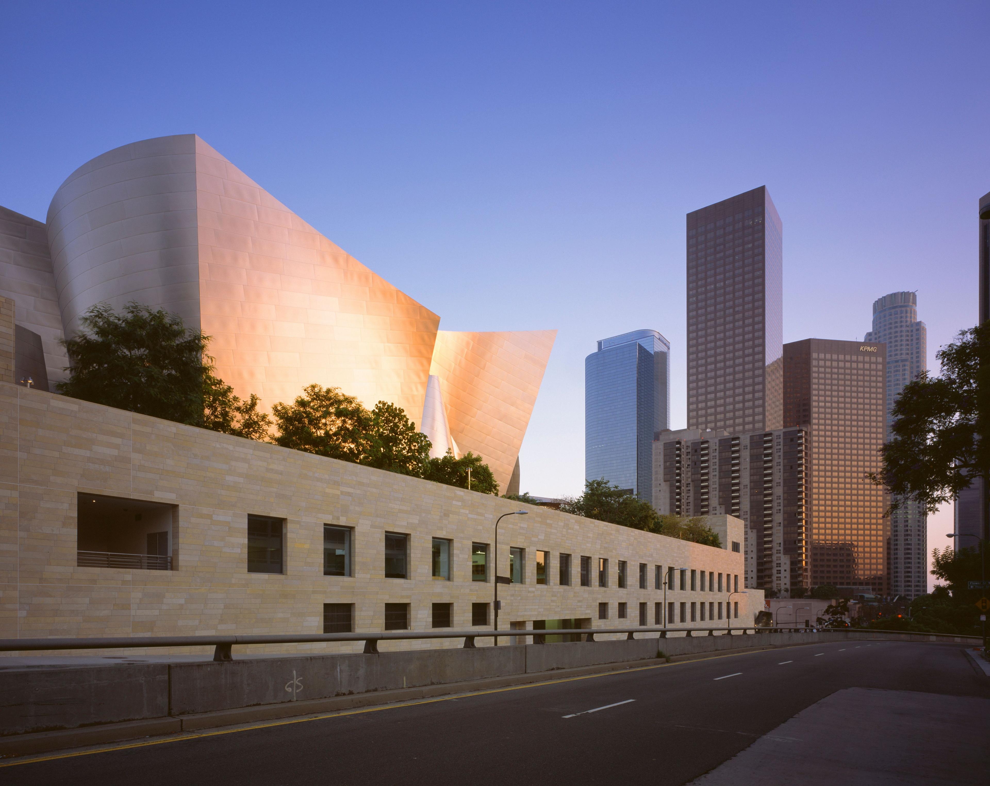 The Walt Disney Concert Hall in Los Angeles is seen from the street outside and juxtaposed with the imposing skyscrapers on central LA