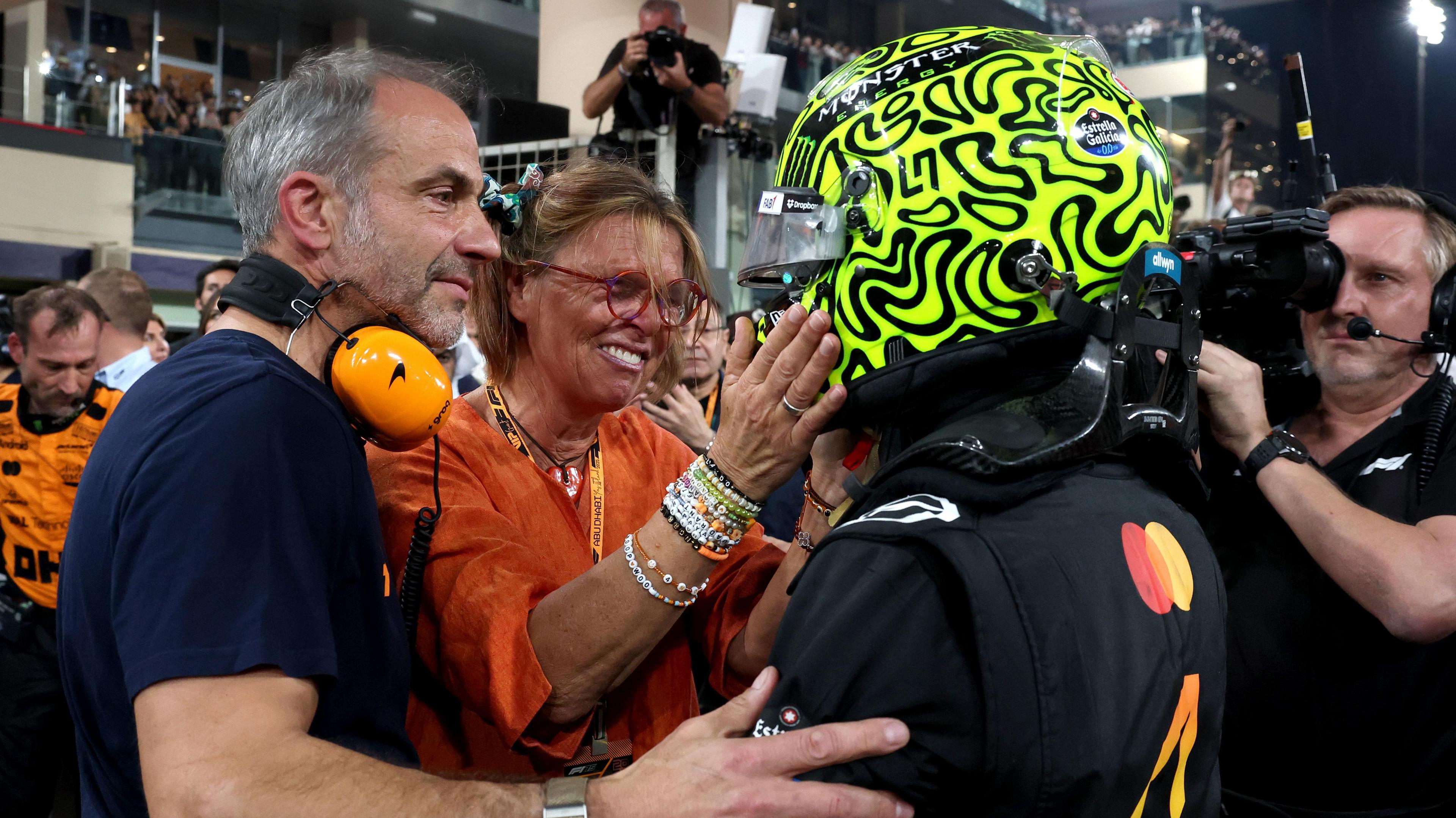 Lando Norris is embraced by his mum Cisca with dad Adam also next to him just after the conclusion of the Abu Dhabi Grand Prix