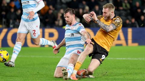 Wrexham defender Dom Hyam (left) is beaten to the ball by Hull City goal scorer Oli McBurnie (right)
