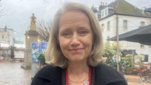 Deputy Kristina Moore is pictured in the Royal Square. She is wearing a black coat.