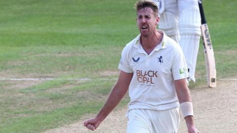 Matt Quinn celebrates with arms outstretched after taking a wicket for Kent