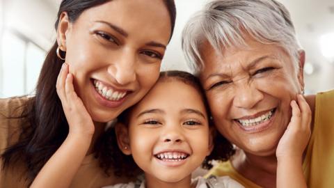 Three generations of women smiling at the camera