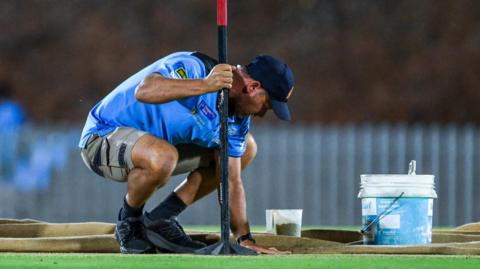 Groundstaff attend to pitch in Adelaide
