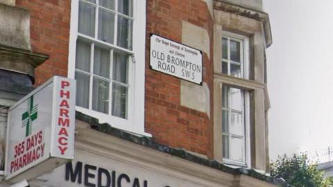 A general view of a street sign attached to a building. It reads: Old Brompton Road.