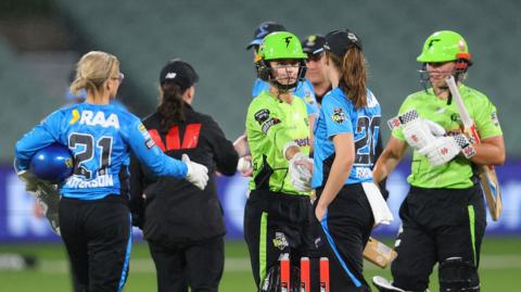 Phoebe Litchfield of the Sydney Thunder and Darcie Brown of the Adelaide Strikers shake hands as the match is abandoned due to rain during the WBBL match between Adelaide Strikers and Sydney Thunder