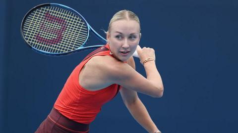 Anastasia Potapova swings a tennis racquet