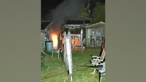 A still from footage showing a fire take hold at a shed in a garden