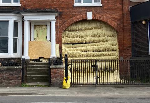 The exterior of a house with yellow foam pumped into an archway
