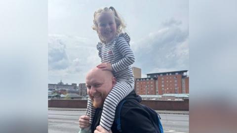 An informal shot of Callum with Eliyah riding on his shoulders