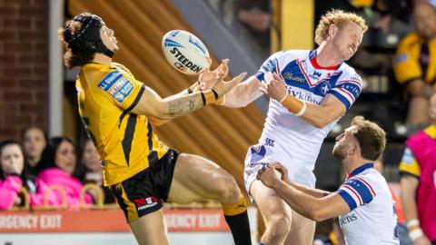 Castleford Tigers player Elliot Wallis and Lachlan Walmsley of Wakefield Trinity contest a high ball.