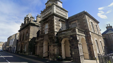 An old two-storey brown-brick court building on a street in Wick