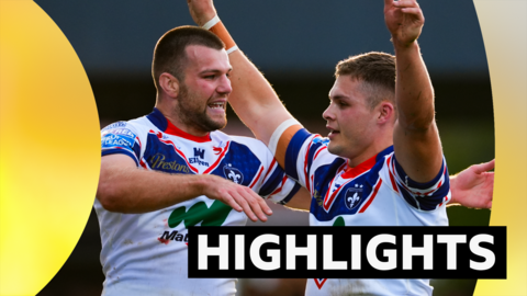 Cam Scott (right) holds his arms in the air as a team-mate puts arms out to hug him