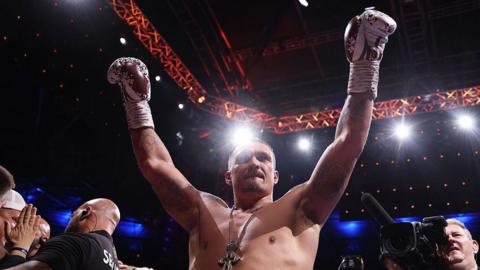 Oleksandr Usyk celebrates victory over Daniel Dubois with his arms raised