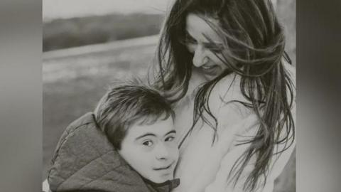 Antonio (L) with his mother Milena (R) in a black and white photo on what appears to be a beach or countryside.
