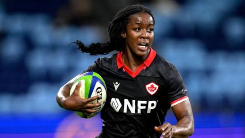 Pamphinette Buisa runs with the ball tucked under her arm during a Pacific Four match for Canada in 2024