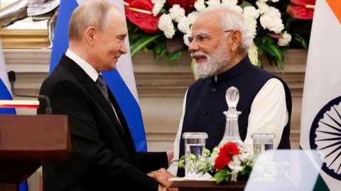 Russian President Vladimir Putin and India's Prime Minister Narendra Modi shake hands as they attend a presentation of a joint statement after their delegation level talks at Hyderabad House in New Delhi/