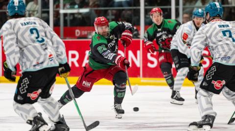 Cardiff Devils' Evan Mosey shoots through a crowd against Belfast Giants