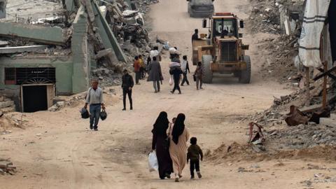 People walk among the rubble in Khan Younis, in the southern Gaza Strip, 06 December 2025.