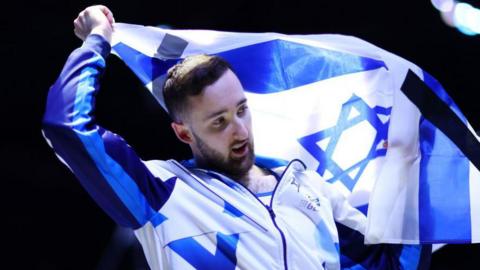 Israel's Artem Dolgopyat with the country's flag at the 2023 World Artistic Gymnastics Championships in Antwerp, Belgium