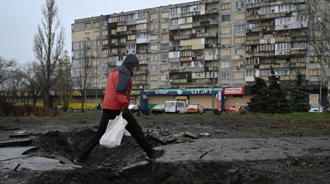 A man walking over an explosion site