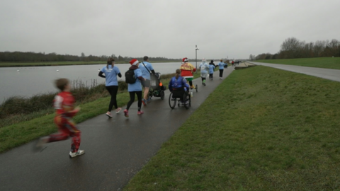 Image of people running, walking, pushing and wheeling by Dorney Lake in Windsor.