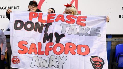 Salford Red Devils fans hold up a flag