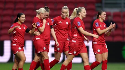 Bristol City Women players celebrate on the pitch after scoring a goal in their 7-0 win against Ipswich