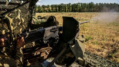 A Ukrainian troop trains using a large machine gun