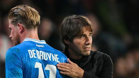 Antonio Conte pats Kevin de Bruyne on the back