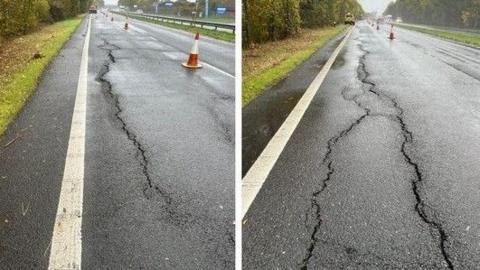 Road with inside land coned off and large crack seen running along its length.