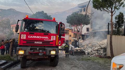 Lebanese Civil Defence members inspect a destroyed building following an Israeli air strike in Jbaa, southern Lebanon (4 December 2025)