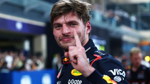 Max Verstappen lifts his left index finger in celebration after taking pole position for the Abu Dhabi Grand Prix