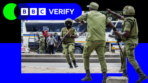 Armed Tanzanian police stand in the streets as demonstrations continue around them.