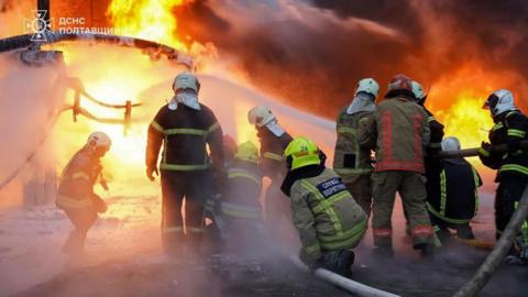 firefighters battle flames at the sit of a Russian strike