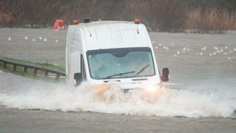 Van drives through high water in Seaton, Cornwall