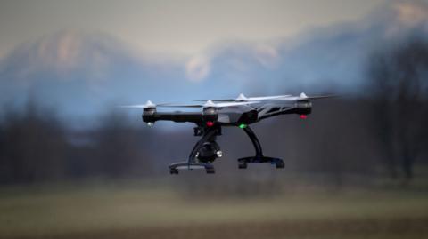 A drone in flight, over a rural location