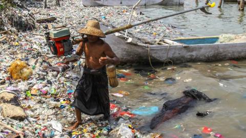 A fisherman arrives at the beach full of rubbish that mostly consists of plastics thrown by local residents and brought by sea currents from various locations in the Kwanyar district, Bangkalan, Madura Island of Indonesia