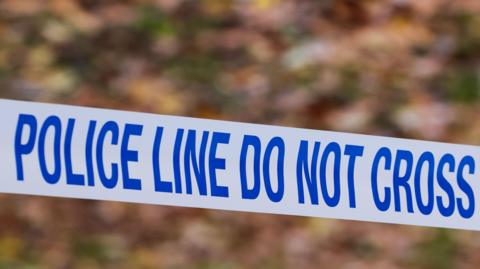 Police tape reading the words, "Police line do not cross"