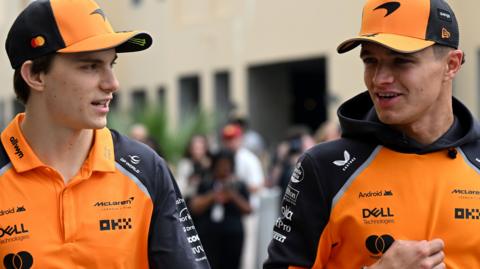 McLaren drivers Oscar Piastri and Lando Norris having a conversation as they arrive at the Abu Dhabi Grand Prix on Friday