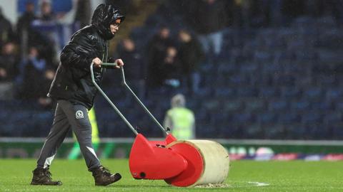 Ground staff working on the pitch at Ewood Park