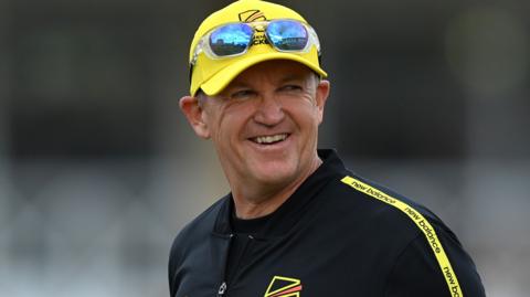 Andy Flower smiles, wearing a Trent Rockets cap
