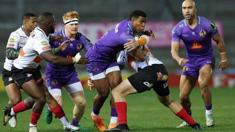 Manny Feyi-Waboso is tackled by Cheetahs forward De-an Ackermann