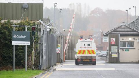 A police Land Rover drives past a security hut